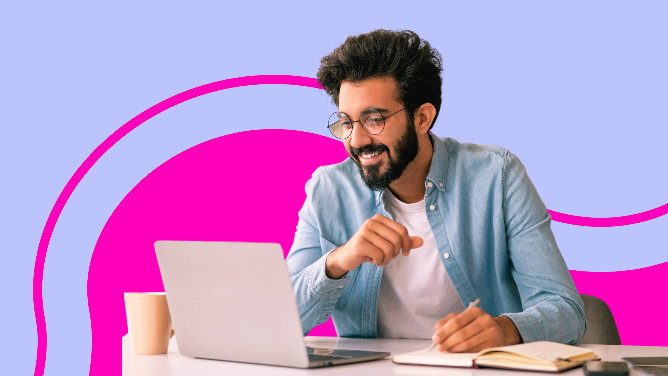 A startup founder sitting at a laptop writing in a notebook, planning his marketing strategy